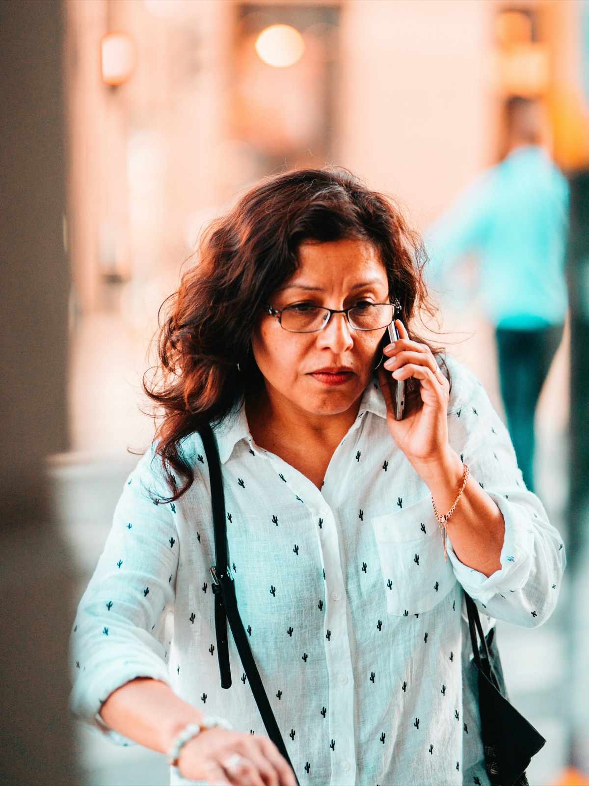 A shelter manager on her phone on the sidewalk, mid-call, early in the day